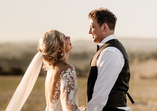 • “Bride and groom standing hand in hand outside Runa Farm’s rustic stone barn – a perfect Durham wedding venue.” • “Candid wedding moment at Runa Farm – newlyweds laughing together under twinkling lights.” • “Elegant boho wedding dress at Runa Farm – bride posing against the venue’s countryside backdrop.” • “Runa Farm wedding setup – long wooden tables, rustic décor, and soft candlelight for a romantic reception.” • “Sunset wedding portraits at Runa Farm – golden hour glow over the rolling Durham countryside.” • “Stylish groom at Runa Farm – a modern take on rustic wedding fashion.” • “The moment they said ‘I do’ – bride and groom exchanging vows in Runa Farm’s barn ceremony space.” • “Runa Farm wedding celebrations – guests raising a toast in a beautifully styled barn reception.” • “Newlyweds sharing their first dance at Runa Farm – a magical moment under fairy lights.” • “Fun wedding party portraits at Runa Farm – bridesmaids and groomsmen celebrating in the countryside.” • “Beautiful wedding bouquet at Runa Farm – dried florals, soft pastels, and rustic charm.” • “Relaxed wedding morning at Runa Farm – bride enjoying a quiet moment before the ceremony.” • “Outdoor wedding drinks reception at Runa Farm – couples and guests enjoying the sunshine and countryside views.” • “Romantic countryside wedding at Runa Farm – couple walking through lush fields at sunset.” • “Runa Farm wedding cake – elegant design with dried flowers and a rustic-luxe finish.” • “Bridal party getting ready at Runa Farm – laughter, champagne, and the perfect pre-wedding moments.” • “Emotional groom watching his bride walk down the aisle at