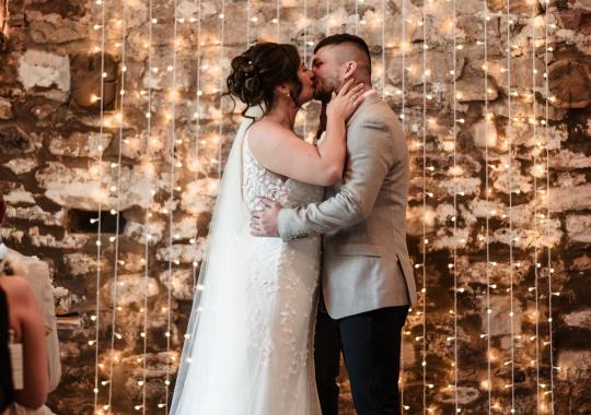 Romantic wedding at Eden Barn, Cumbria – rustic stone barn with fairy lights and countryside views. Bride and groom at Eden Barn, a charming wedding venue in Cumbria with exposed stone walls and wooden beams. Rustic wedding reception at Eden Barn – elegant tablescapes, candlelight, and floral decor in a historic barn setting. Outdoor wedding ceremony at Eden Barn, Cumbria – scenic countryside backdrop with a beautifully styled aisle. Bride and groom sharing their first dance under fairy lights in the atmospheric Eden Barn, Cumbria. Candid wedding photography at Eden Barn – newlyweds enjoying a golden hour moment in the Cumbrian countryside. Intimate wedding dinner at Eden Barn, Cumbria – rustic wooden tables, greenery, and soft lighting. Eden Barn wedding venue – a romantic, family-run barn in the heart of Cumbria’s rolling countryside. Bridal portrait at Eden Barn, Cumbria – stunning wedding dress captured in soft natural light. Groom’s first look reaction at Eden Barn – emotional moment in a rustic barn wedding setting. Evening wedding reception at Eden Barn – cozy, candlelit barn with fairy lights and dancing. Wedding cake display at Eden Barn, Cumbria – beautifully decorated rustic cake with floral accents. Bridal party celebrations at Eden Barn – bridesmaids and groomsmen enjoying the stunning countryside venue. Sunset wedding photography at Eden Barn – breathtaking golden hour shots of the newlyweds. Confetti moment at Eden Barn, Cumbria – joyful wedding guests celebrating outside the historic stone barn. Rustic wedding details at Eden Barn – boho-inspired table settings, wildflowers, and vintage decor. Emotional wedding vows at Eden Barn – heartfelt ceremony in a charming countryside barn setting. Bride and groom walking hand in hand at Eden Barn – natural and relaxed wedding photography. Live wedding band at Eden Barn – guests dancing under the twinkling fairy lights in a rustic barn venue. Luxury barn wedding at Eden Barn, Cumbria – elegant styling meets countryside charm for the perfect day.