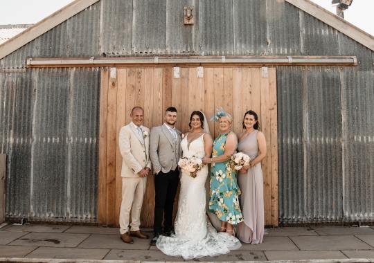 Romantic wedding at Eden Barn, Cumbria – rustic stone barn with fairy lights and countryside views. Bride and groom at Eden Barn, a charming wedding venue in Cumbria with exposed stone walls and wooden beams. Rustic wedding reception at Eden Barn – elegant tablescapes, candlelight, and floral decor in a historic barn setting. Outdoor wedding ceremony at Eden Barn, Cumbria – scenic countryside backdrop with a beautifully styled aisle. Bride and groom sharing their first dance under fairy lights in the atmospheric Eden Barn, Cumbria. Candid wedding photography at Eden Barn – newlyweds enjoying a golden hour moment in the Cumbrian countryside. Intimate wedding dinner at Eden Barn, Cumbria – rustic wooden tables, greenery, and soft lighting. Eden Barn wedding venue – a romantic, family-run barn in the heart of Cumbria’s rolling countryside. Bridal portrait at Eden Barn, Cumbria – stunning wedding dress captured in soft natural light. Groom’s first look reaction at Eden Barn – emotional moment in a rustic barn wedding setting. Evening wedding reception at Eden Barn – cozy, candlelit barn with fairy lights and dancing. Wedding cake display at Eden Barn, Cumbria – beautifully decorated rustic cake with floral accents. Bridal party celebrations at Eden Barn – bridesmaids and groomsmen enjoying the stunning countryside venue. Sunset wedding photography at Eden Barn – breathtaking golden hour shots of the newlyweds. Confetti moment at Eden Barn, Cumbria – joyful wedding guests celebrating outside the historic stone barn. Rustic wedding details at Eden Barn – boho-inspired table settings, wildflowers, and vintage decor. Emotional wedding vows at Eden Barn – heartfelt ceremony in a charming countryside barn setting. Bride and groom walking hand in hand at Eden Barn – natural and relaxed wedding photography. Live wedding band at Eden Barn – guests dancing under the twinkling fairy lights in a rustic barn venue. Luxury barn wedding at Eden Barn, Cumbria – elegant styling meets countryside charm for the perfect day.